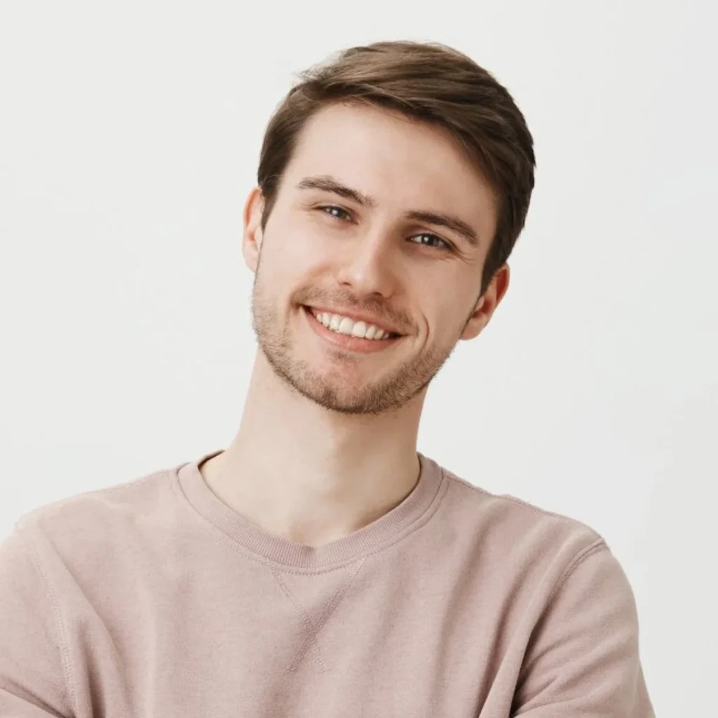 Portrait of young man in pale shirt.