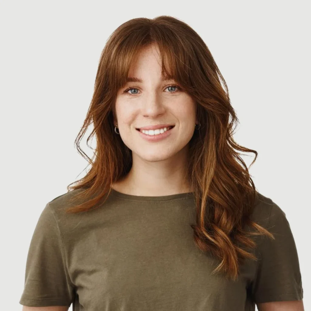 Portrait of woman with long brown hair and olive shirt.
