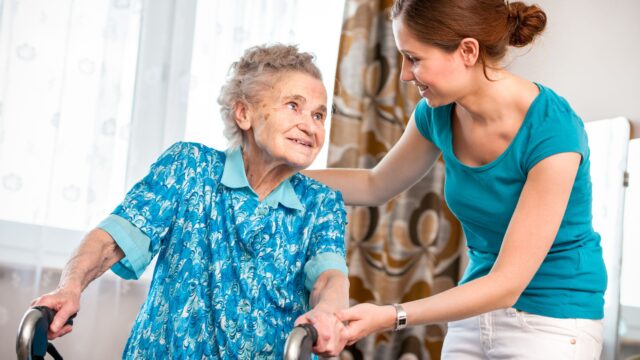 Physiotherapist guiding elderly woman