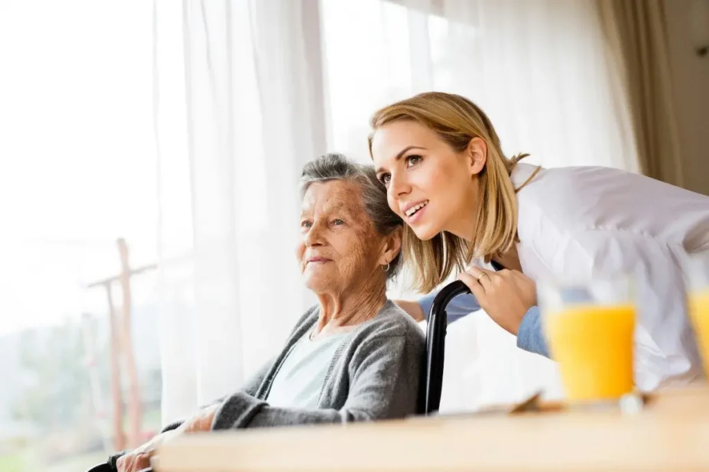 Woman reassuring senior with hand on shoulder.