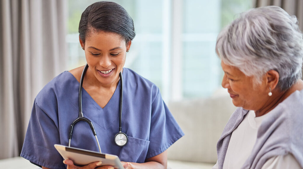 Nurse recording medical data with senior patient.