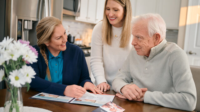 Group discussing paperwork at a dining table.