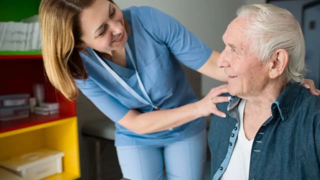 Nurse talking affectionately with senior man.