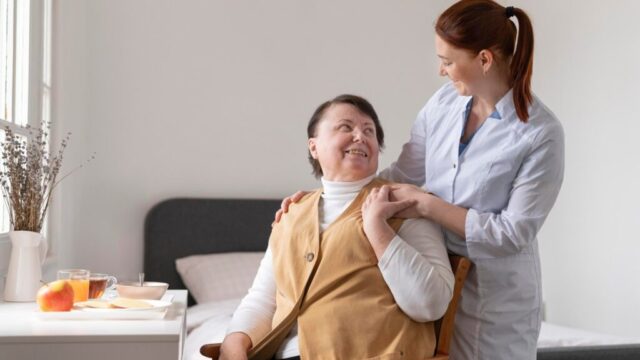 Care worker gently holding senior's shoulder.
