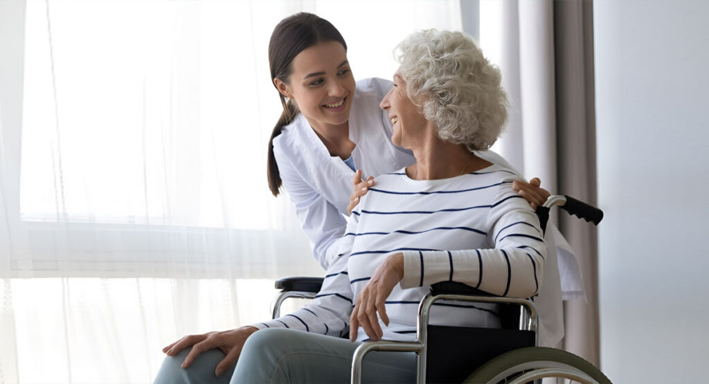 Woman hugging her grandmother in a wheelchair.