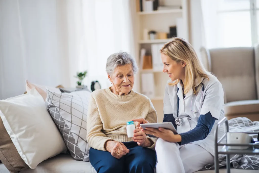 Nurse explaining medication to senior patient at home.