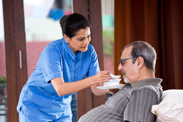 Healthcare worker feeding soup to an older man.
